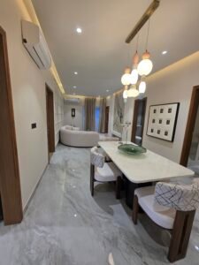 About “Spacious living room at Hare Krishna Ashiyana in Vrindavan with modern interiors, elegant lighting, and premium finishes”